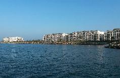 Picture: "Yachthafenresidenz Hohe Düne" seen from the ferry crossing the river. Left the congress centre.